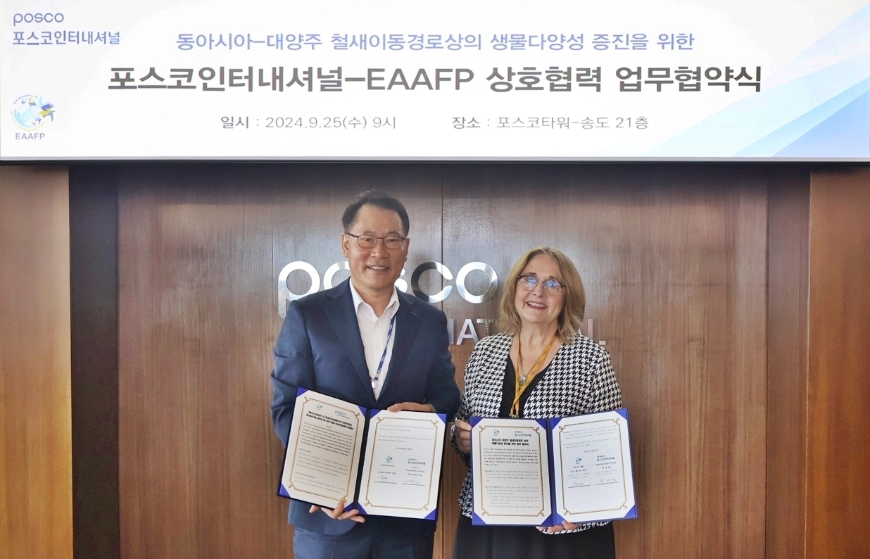 Heo Sung-hyung (left), head of Posco International Sustainability Management Office, and Jennifer George, chief executive of EAAFP, pose for a photo during the signing event at the Songdo Posco Tower in Incheon on Wednesday. (Posco International)