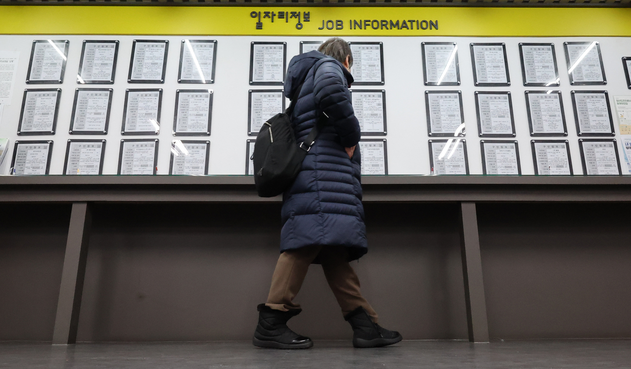 A person walks by a job information board at a government-affiliated center for job seekers in Seoul on Feb. 14. (Yonhap)