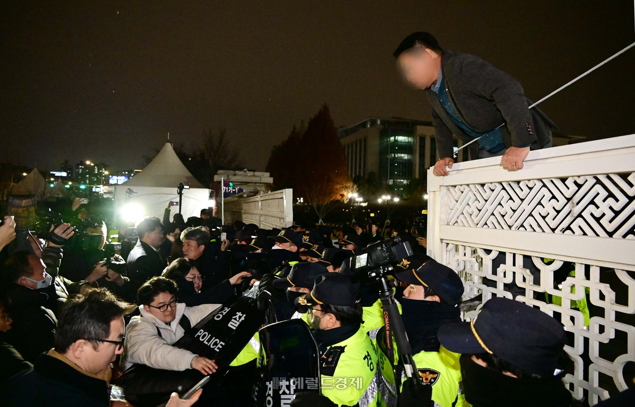 12·3 비상계엄 선포 다음 날인 4일 새벽 국회 관계자들이 서울 영등포구 여의도 국회에 들어가고 있다. [이상섭 기자]