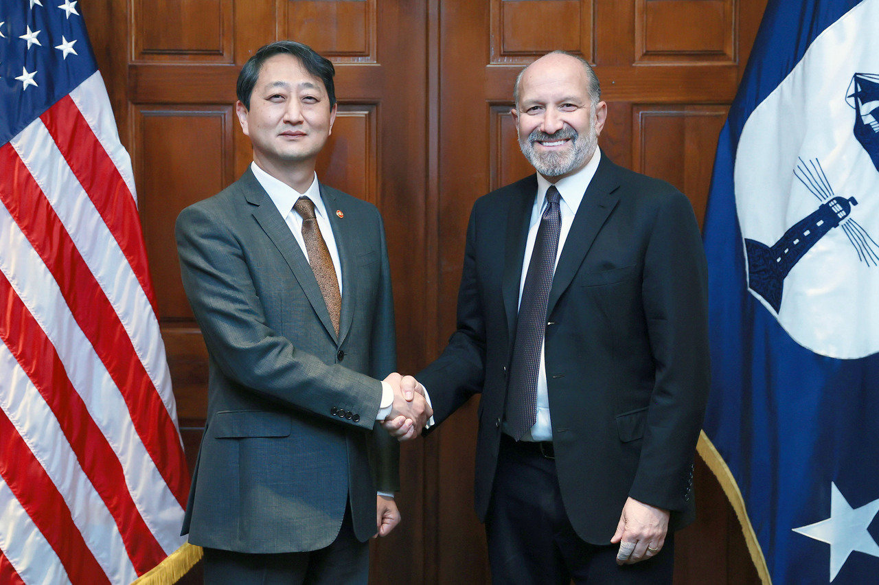 South Korean Industry Minister Ahn Duk-geun (left) shakes hands with US Commerce Secretary Howard Lutnick at the Department of Commerce in Washington, DC, on Thursday. (Ministry of Trade, Industry and Energy)