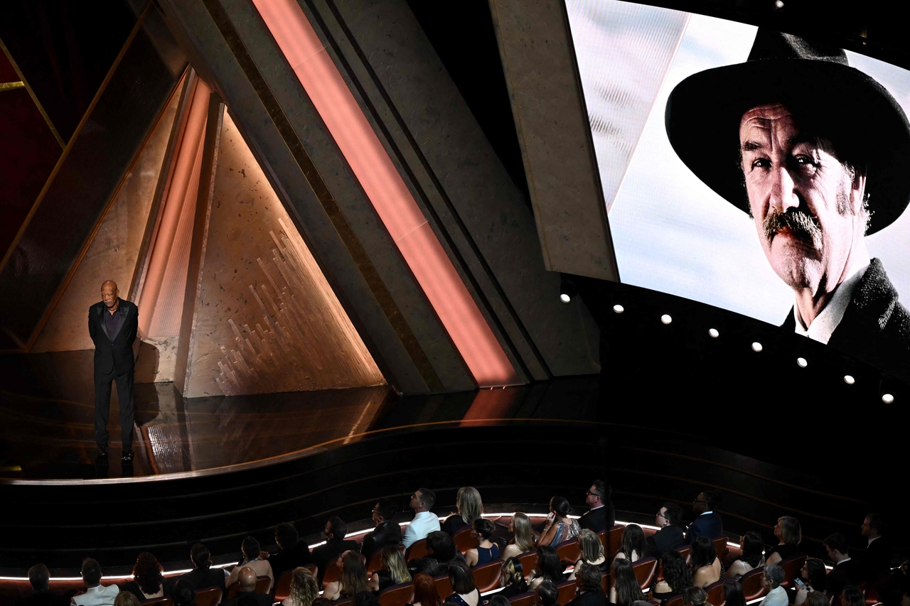 Late US actor Gene Hackman is seen on a screen as US actor Morgan Freeman stands onstage during the 97th Annual Academy Awards at the Dolby Theatre in Hollywood, California on Sunday. (AFP-Yonhap)