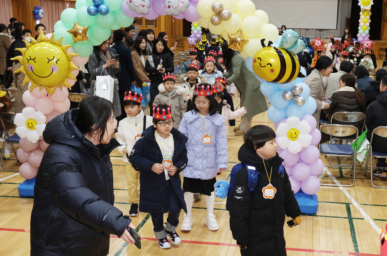 Students head over to their classrooms under a teacher's guidance. (Yonhap)