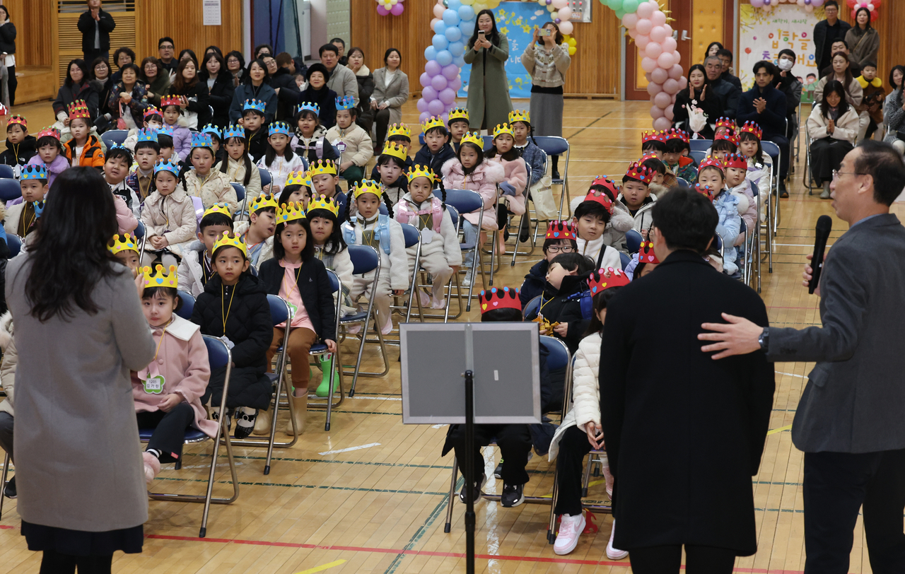 First graders and their guardians are introduced to the homeroom teachers who will guide the students this academic year. (Yonhap)