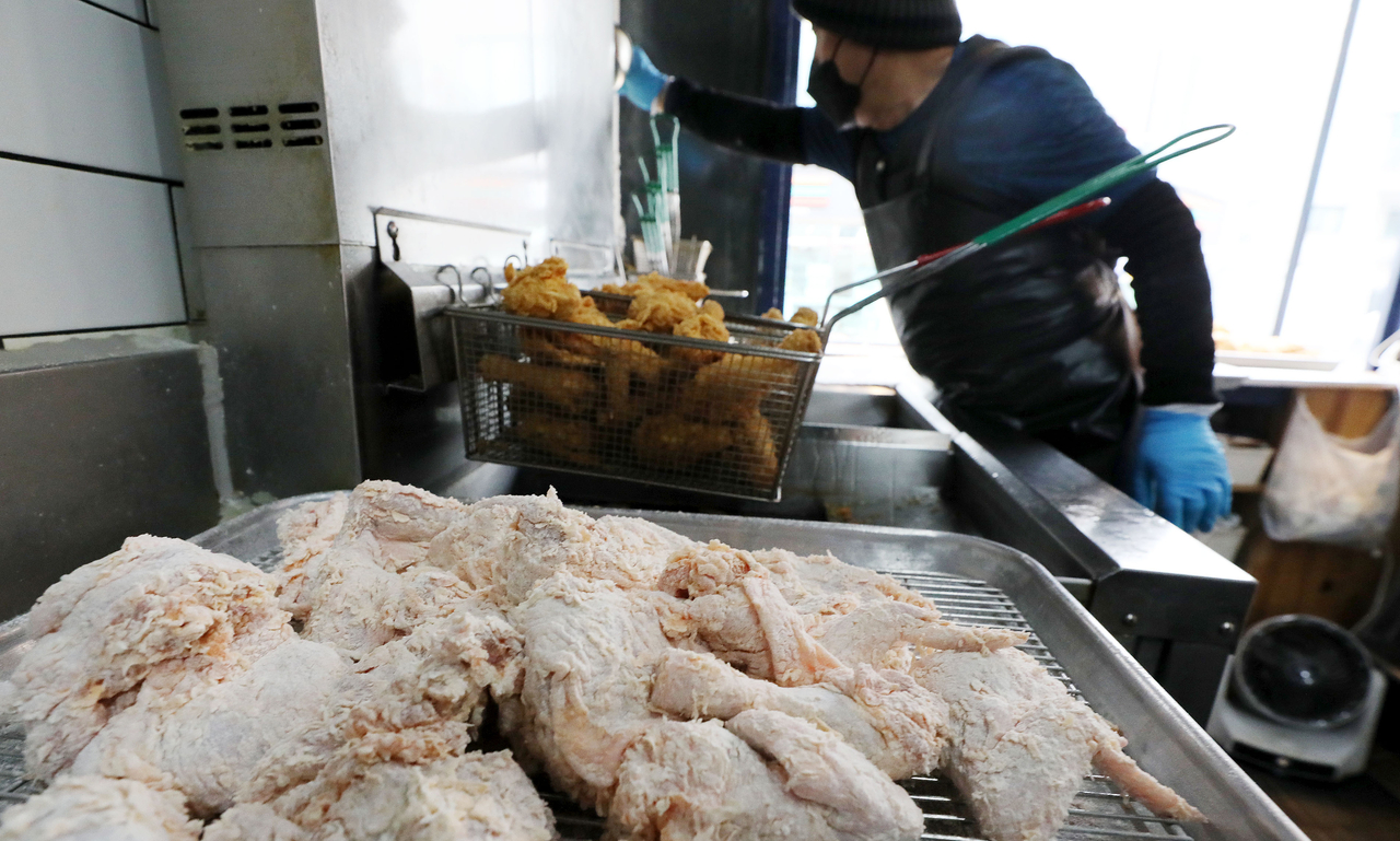 서울 시내 한 치킨 가맹점에서 점주가 치킨을 튀기고 있다. [뉴시스]