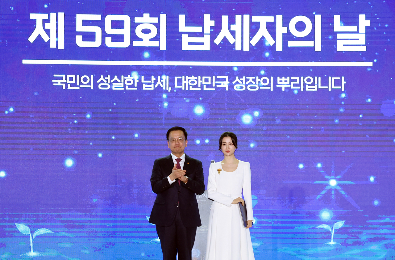 최상목 대통령 권한대행 부총리 겸 기획재정부 장관이 4일 서울 중구 동대문디자인플라자(DDP) 아트홀에서 열린 제59회 납세자의 날 기념식에서 배우 박하선 씨에게 표창을 수여한 뒤 기념촬영을 하고 있다. ［연합］