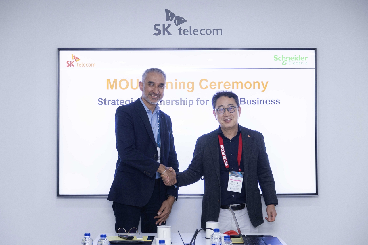 SK Telecom CEO Ryu Young-sang (right) and Pankaj Sharma, executive vice president of secure power division at Schneider Electric, pose for a photo in Barcelona, Spain, Tuesday. (SK Telecom)