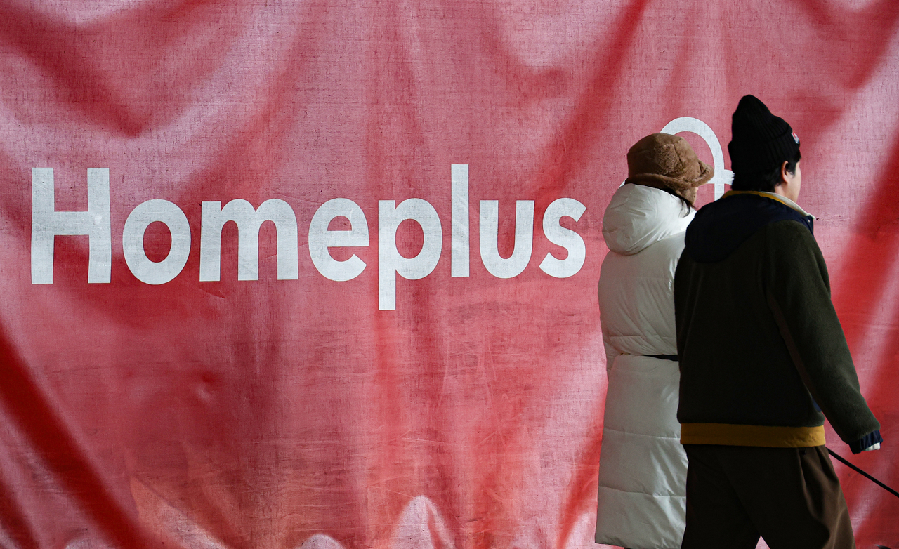 Customers pass by a Homeplus logo at a Seoul branch on Tuesday. (Yonhap)