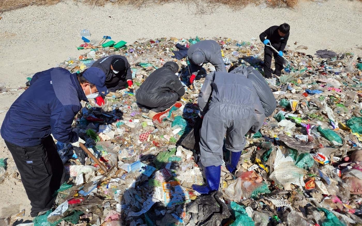 Civil servants from the local sanitation department search through the garbage at an area central waste processing station to help a woman find 26 million won she had accidentally thrown away in Sejong City, Feb. 24. (Sejong City)