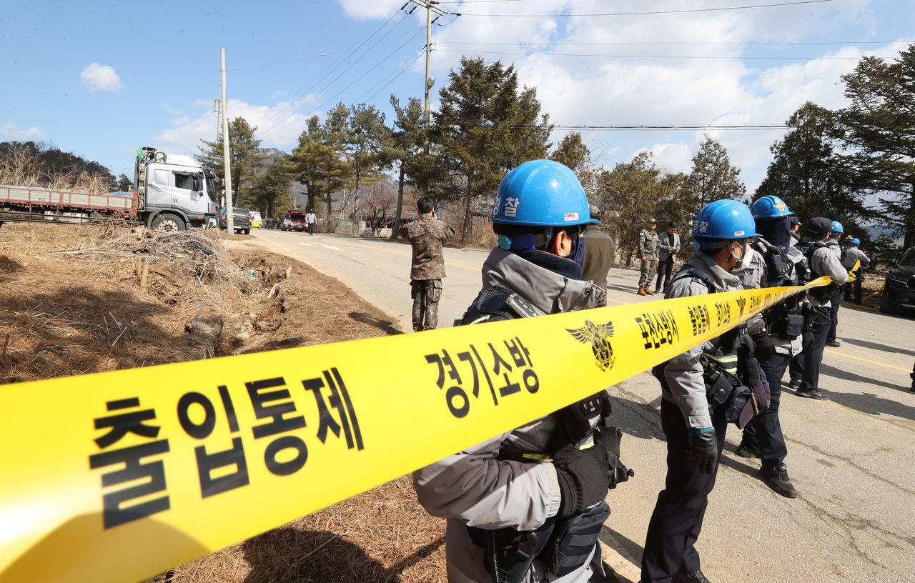Security personnel guard a site where an object believed to be a shell that accidentally dropped from a South Korean fighter jet fell on a home in Idong-myeon, Pocheon, Gyeonggi Province, Thursday. Yonhap