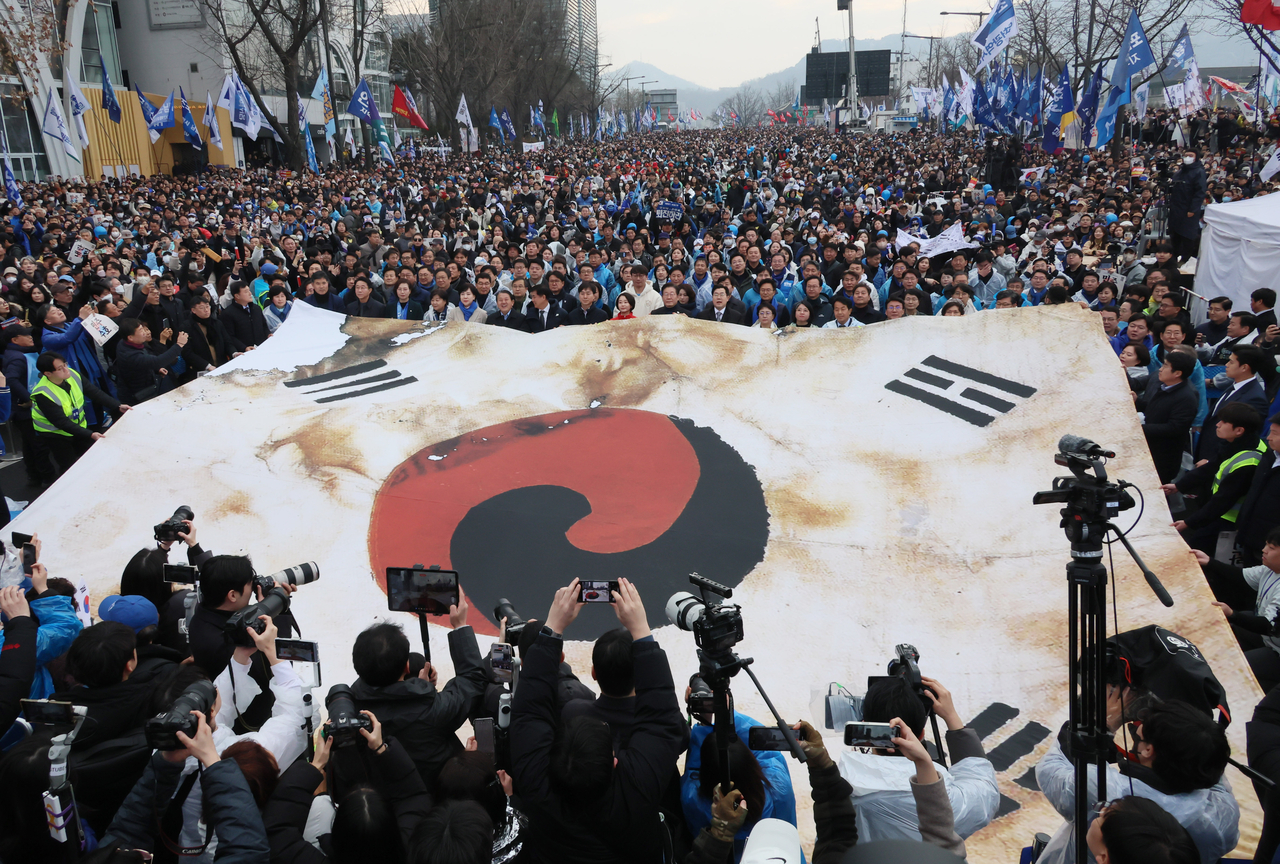 Participants at the rally calling for President Yoon Suk Yeol's removal from his office unfurl a giant national flag in Jongno-gu, Seoul on Saturday. (Yonhap)