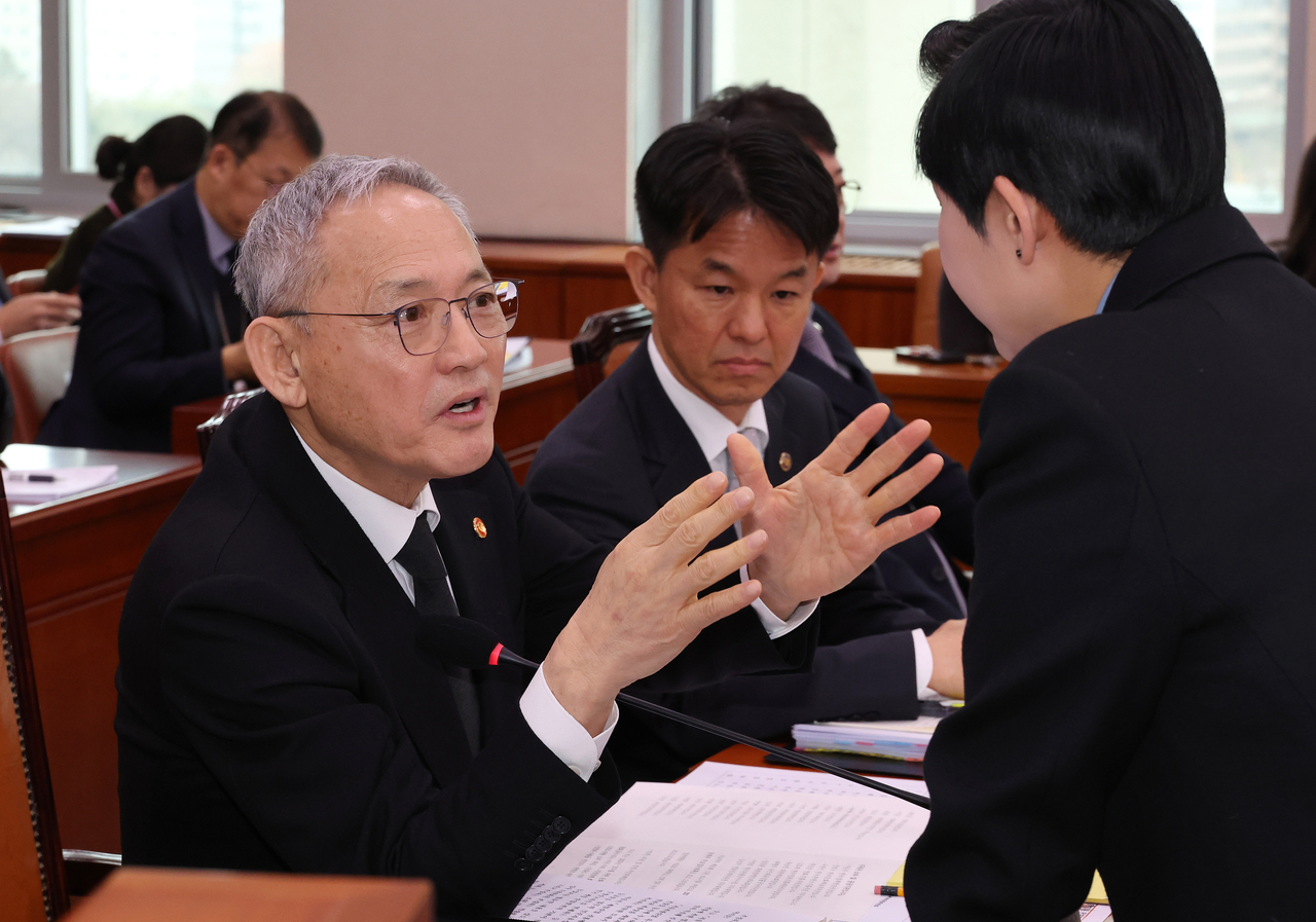Minister of Culture, Sports and Tourism Yu In-chon (left) speaks with singer-turned-lawmaker Kim Jae-won during a session of the National Assembly's Culture, Sports and Tourism Committee held at the National Assembly in Yeouido, Seoul, on Wednesday. (Yonhap)