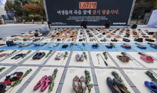 세계 여성 폭력 추방 주간을 맞이해 한국여성의전화 관계자들이 지난해 11월25일 오전 서울 종로구 보신각 앞에서 여성 살해를 규탄하는 ‘192켤레’의 멈춘 신발 퍼포먼스를 하고 있다. 한국여성의전화는 지난 2009년부터 15년 동안 언론 보도를 집계한 결과 ,우리나라에서 남성 파트너에 의해 살해된 여성과 주변인은 최소 1672명, 2023년 한해에는 최소 192명으로 나타났다고 밝혔다. 이날 행사에서 관계자들은 192명의 피해자를 상징하는 192켤레의 신발을 전시하고 바닥에 1672명의 피해자를 상징하는 1672 숫자를 나타내는 퍼포먼스를 펼쳤다. 연합뉴스