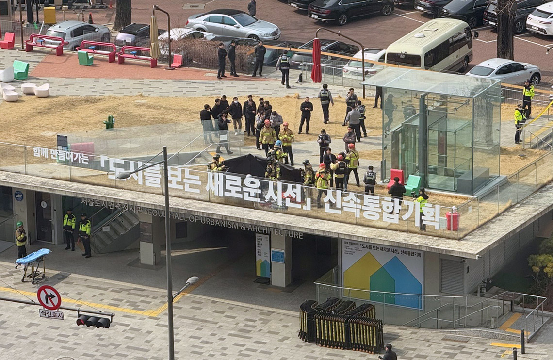 Firefighters respond to the scene where a man, believed to be a supporter of President Yoon Suk Yeol, attempted self-immolation on the rooftop of the Seoul Hall of Urbanism and Architecture, Friday. (Yonhap)
