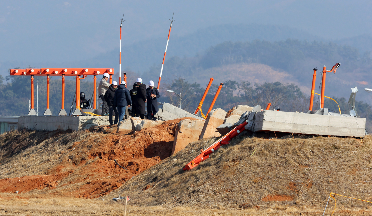 지난달 26일 오후 전남 무안국제공항에서 항공철도사고조사위원회, 경찰, 국과수 관계자들이 방위각시설(로컬라이저)을 살펴보고 있다. [연합]