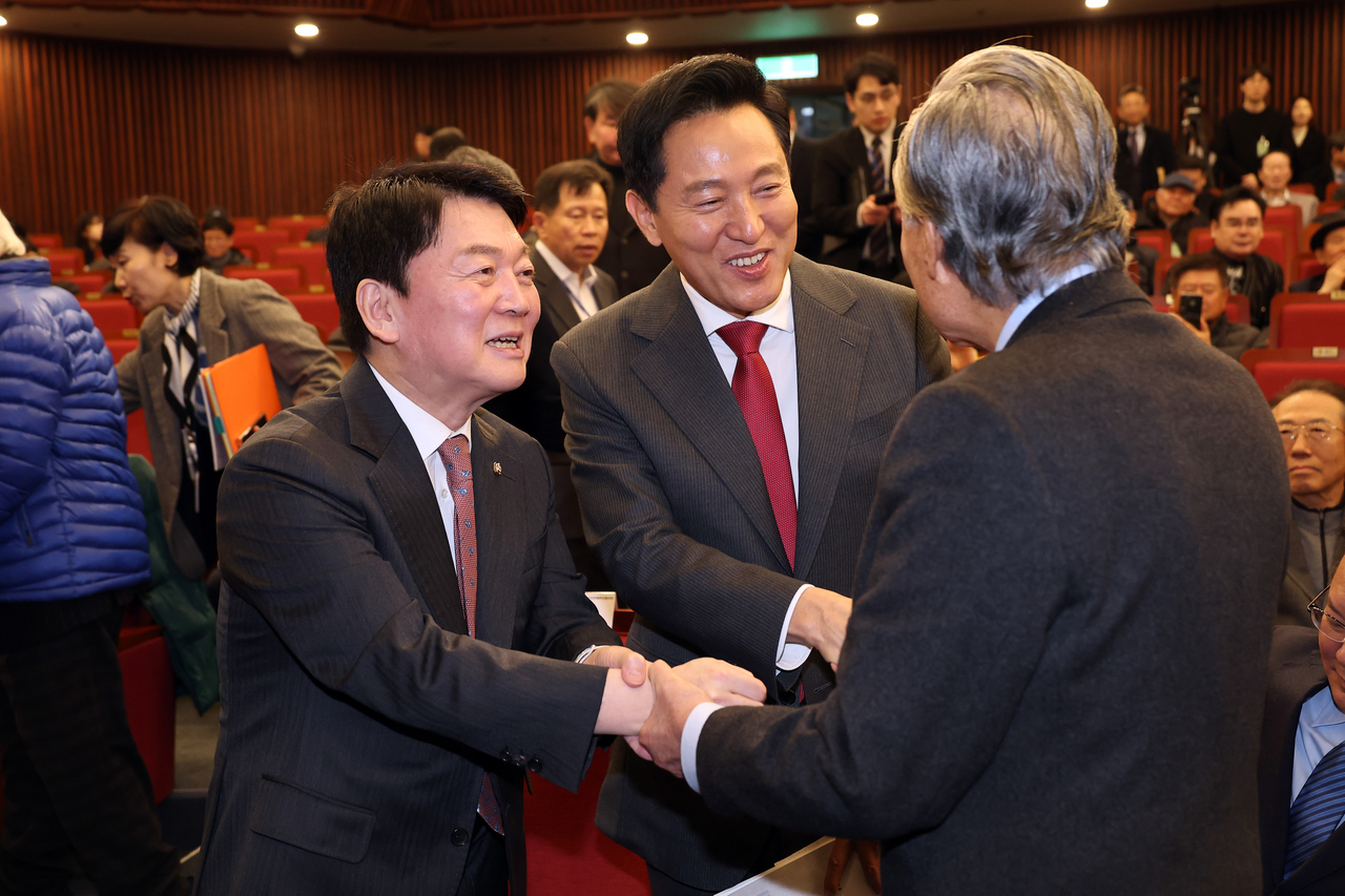6일 서울 여의도 국회도서관에서 열린 ‘분권형 권력구조 개헌 대토론회’에서 오세훈 서울시장(가운데)과 안철수 국민의힘 의원이 참석자들과 인사를 나누고 있다. [연합]