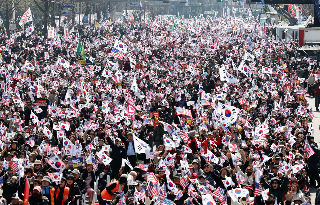 Protestors at the rally opposing President Yoon Suk Yeol’s impeachment wave the South Korean national flag, the Taegeukgi, in front of the Dongwha Duty-Free Shop in Jongno, central Seoul. (Yonhap)