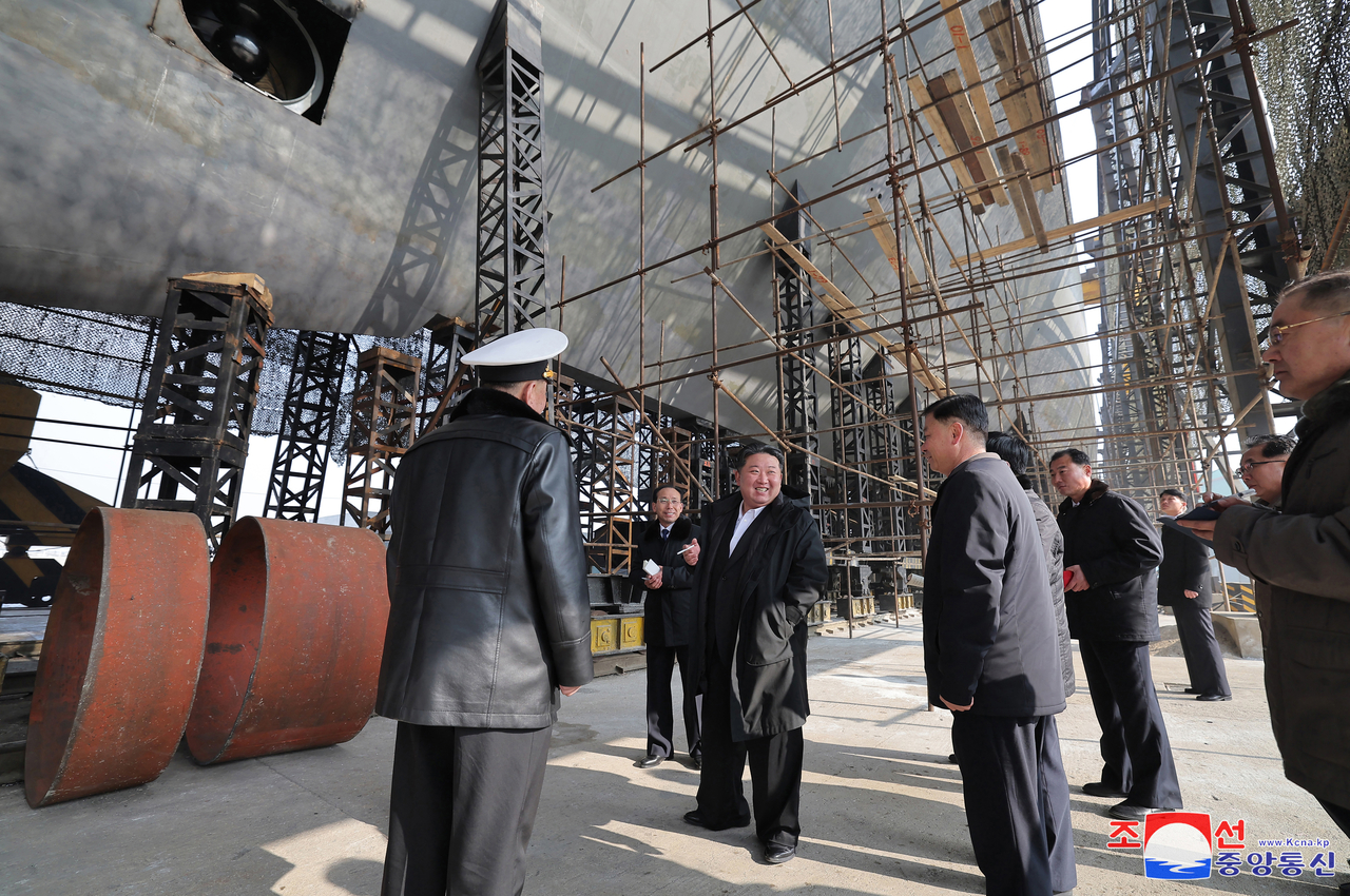 This photo, carried by North Korea's official Korean Central News Agency on March 8, 2025, shows leader Kim Jong-un visiting a major shipyard to inspect the progress of building a nuclear-powered submarine. (Yonhap)