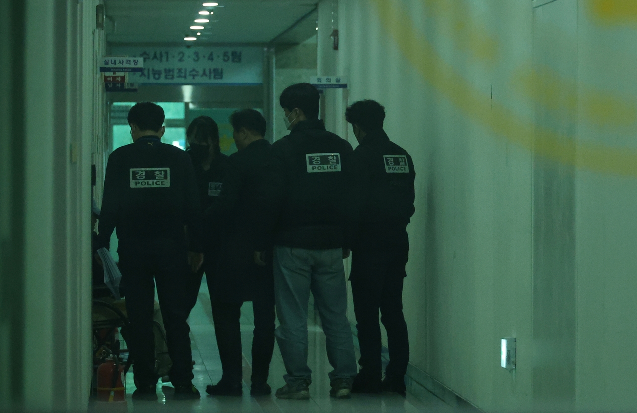 7일 오후 대전서부경찰서에서 첫 대면조사를 마친 대전 초등생 살해 교사 명모(40대) 씨가 조사실을 나오고 있다. 경찰들이 명씨를 유치장에 입감하기 위해 이동시키고 있다. [연합]