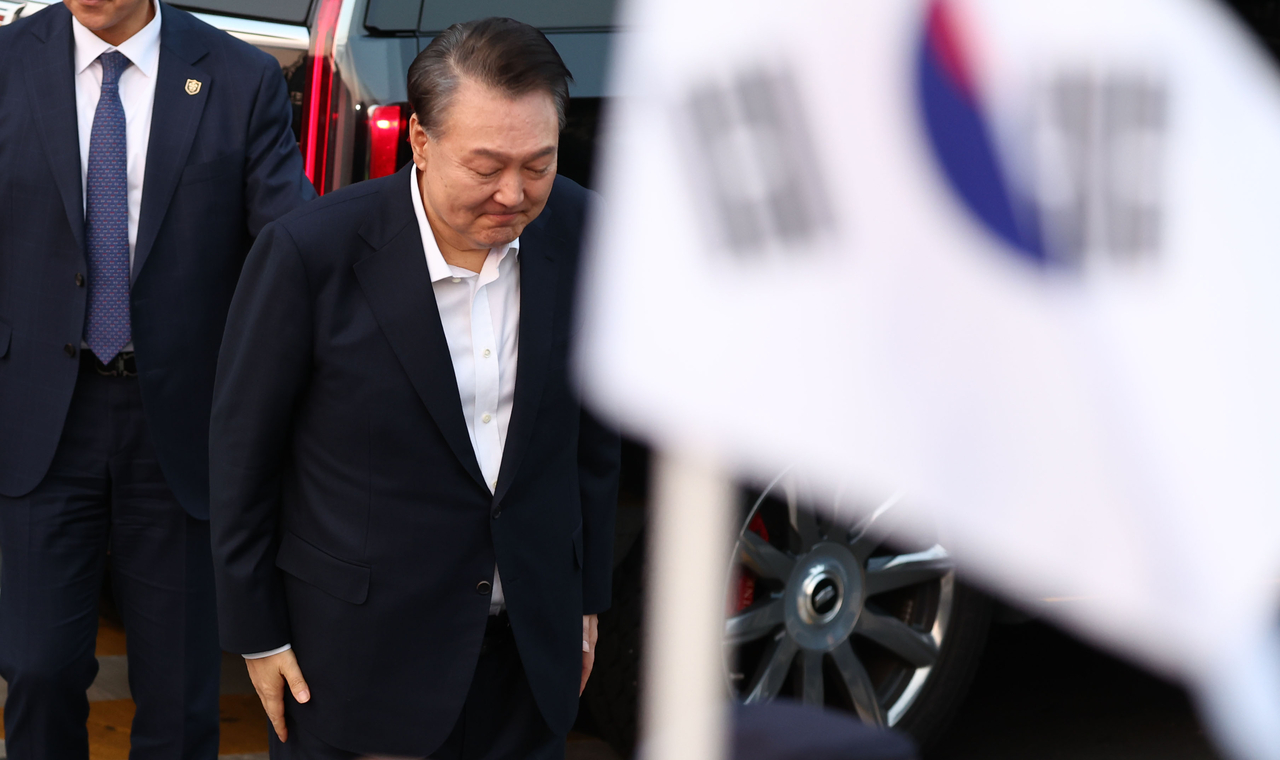 Suspended President Yoon Suk Yeol bows while greeting supporters upon his sudden release from Seoul Detention Center in Uiwang, Gyeonggi Province, Saturday. (Yonhap)