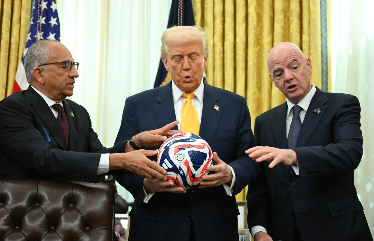 도널드 트럼프 미국 대통령이 지난 7일(현지시간) 백악관 집무실에서 잔니 인판티노 FIFA 회장(오른쪽)이 자리한 가운데, 내년 6∼7월 열리는 북중미월드컵 준비를 위한 태스크포스(TF)를 백악관에 설치하는 내용의 행정명령에 서명했다. 인판티노 FIFA 회장은 이날 트럼프 대통령 이름을 새긴 내년 월드컵 공인구를 선물하고 있다. [AFP]