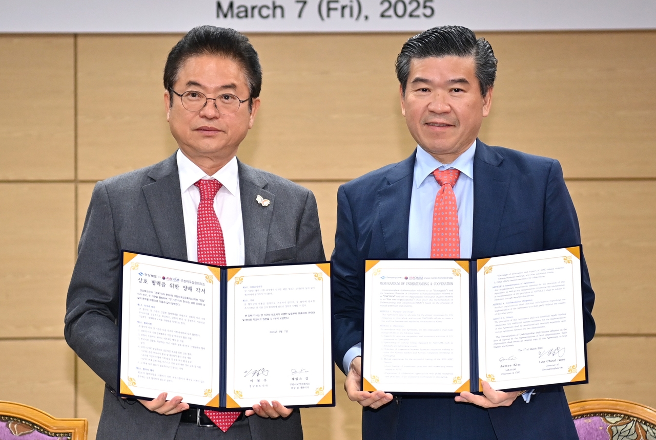 North Gyeongsang Province Gov. Lee Cheol-woo (left) and AmCham Chairman and CEO James Kim pose for a photo during a signing event for a memorandum of understanding in Gyeongju on Friday. (AmCham)
