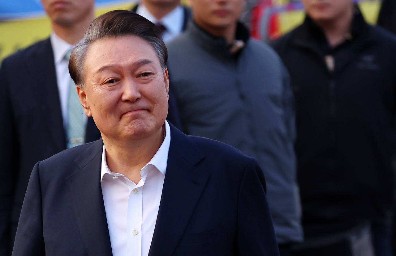 석방된 윤석열 대통령이 8일 경기도 의왕시 서울구치소 앞에서 경호차량에서 내려 지지자들에게 인사하며 구치소를 나서고 있다. [연합]
