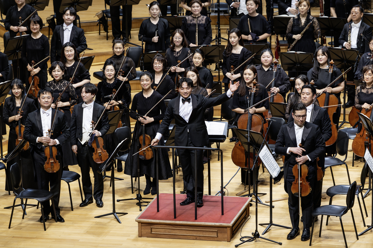 Harris Han Andersen, a participant of the Seoul Philharmonic Orchestra's Conducting Fellowship, greets the audience with the orchestra after a concert on Feb. 28 at Lotte Concert Hall in Seoul. (SPO)