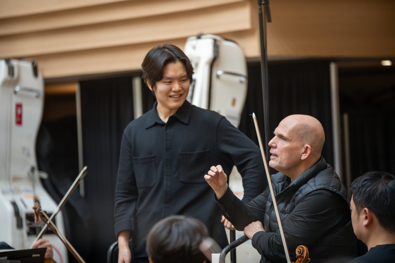 The Seoul Philharmonic Orchestra's Artistic Director Jaap van Zweden (right) and Park Keun-tae, a participant of the SPO Conducting Fellowship, talk during a rehearsal on Feb. 26 at the Sejong Center for the Performing Arts in Seoul. (SPO)
