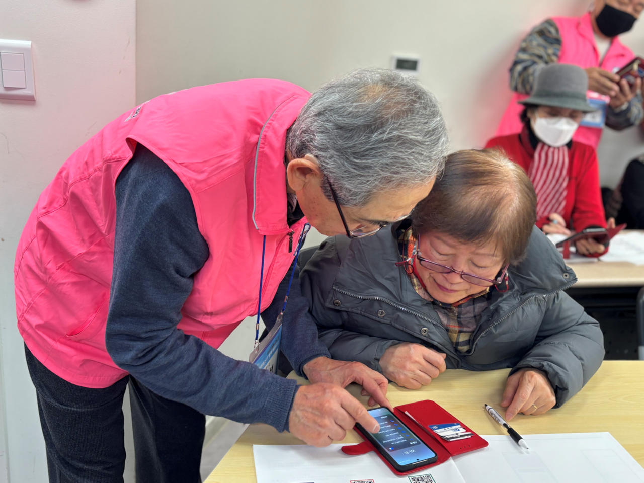 우리금융그룹 우리금융미래재단이 진행하는 ‘우리 어르신 정보기술(IT) 행복 배움교실’에서 지난해 우수 수강생 어르신이 보조강사로 수강생을 돕고 있다. [우리은행 제공]