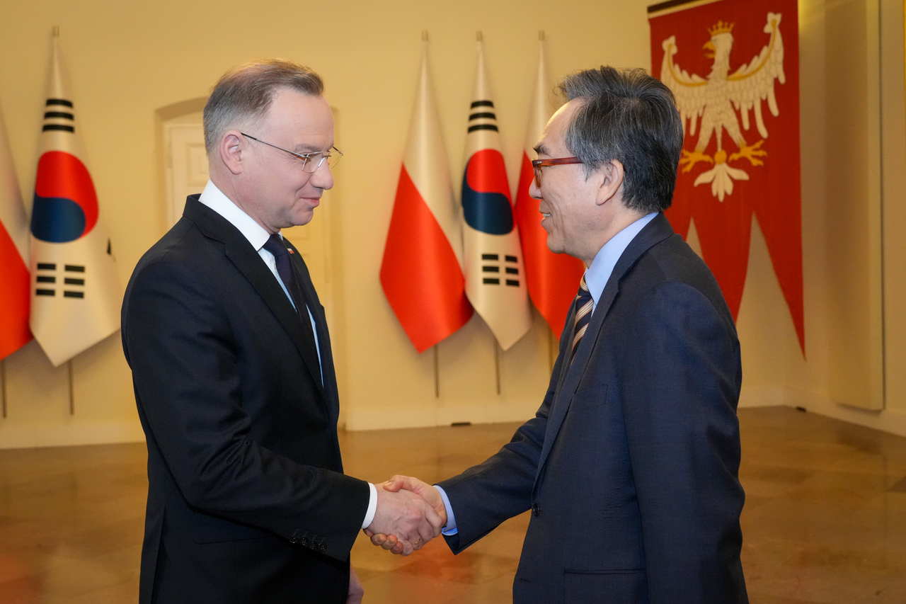 Polish President Andrzej Duda (left) shakes hands with South Korean Foreign Minister Cho Tae-yul on March 6 in Warsaw. (Foreign Ministry)