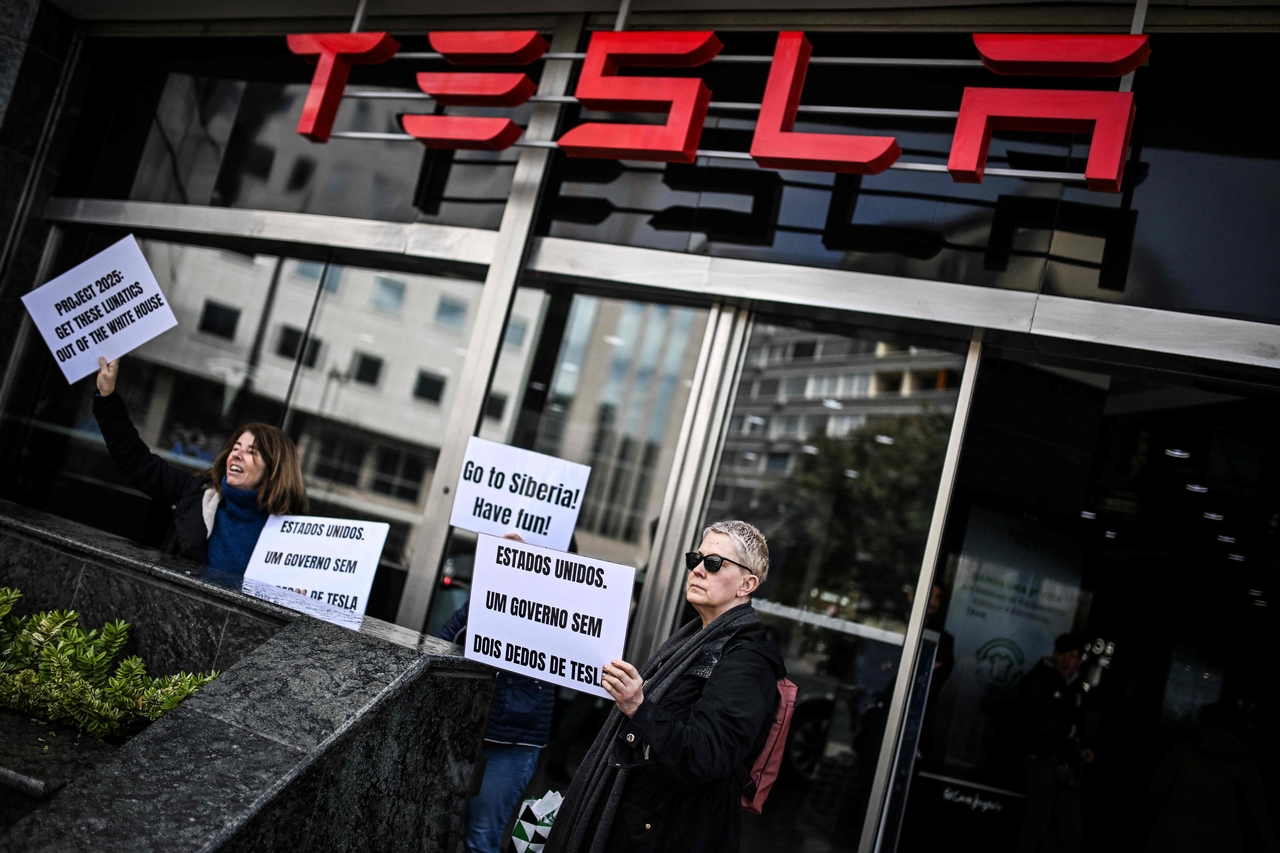 2025년 3월 9일, 리스본의 테슬라 딜러십 밖에서 사람들이 테슬라와 SpaceX CEO 일론 머스크에 대한 항의 시위를 벌이며 플래카드를 들고 있다. 이 시위는 전 세계적으로 시민들이 “테슬라를 팔고, 주식을 처분하고, 피켓 라인에 합류하도록” 격려하는 일련의 행동인 ‘테슬라 테이크다운’ 작전의 일부다. [AFP]