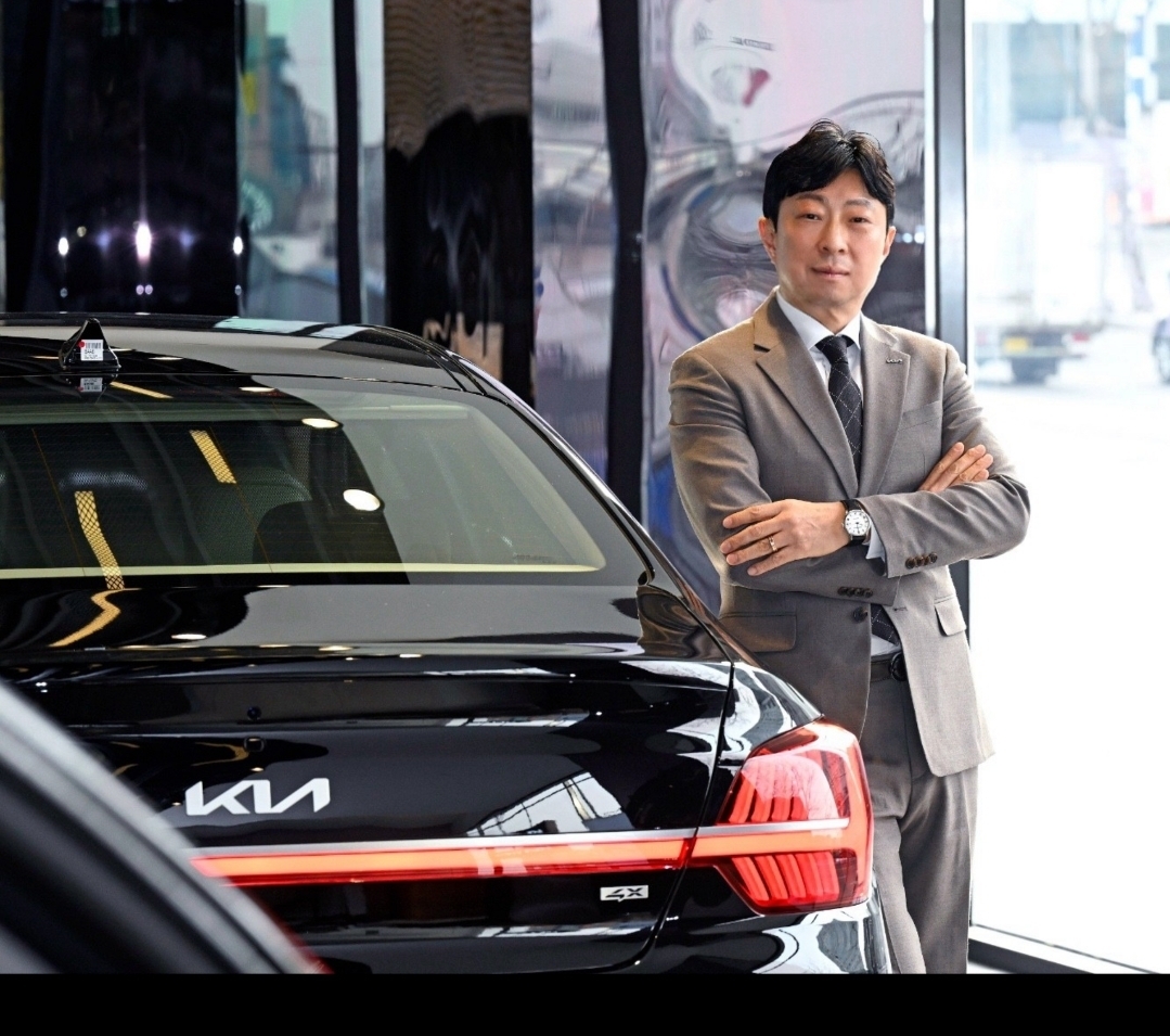 이광욱 기아 상암지점 선임 오토컨설턴트가 차량 앞에서 포즈를 취하고 있다. [본인  제공]