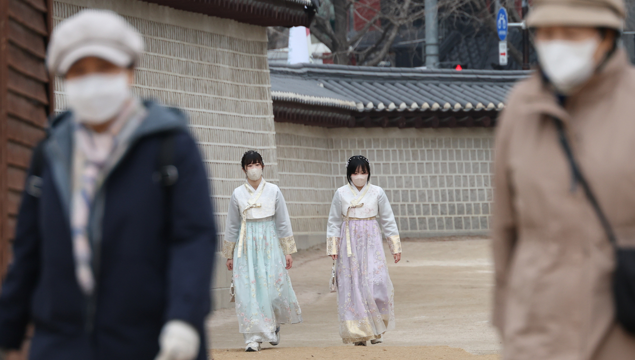 Tourists and citizens walk around wearing face masks near the Gyeongbokgung Palace in Seoul on Wednesday. (Yonhap)