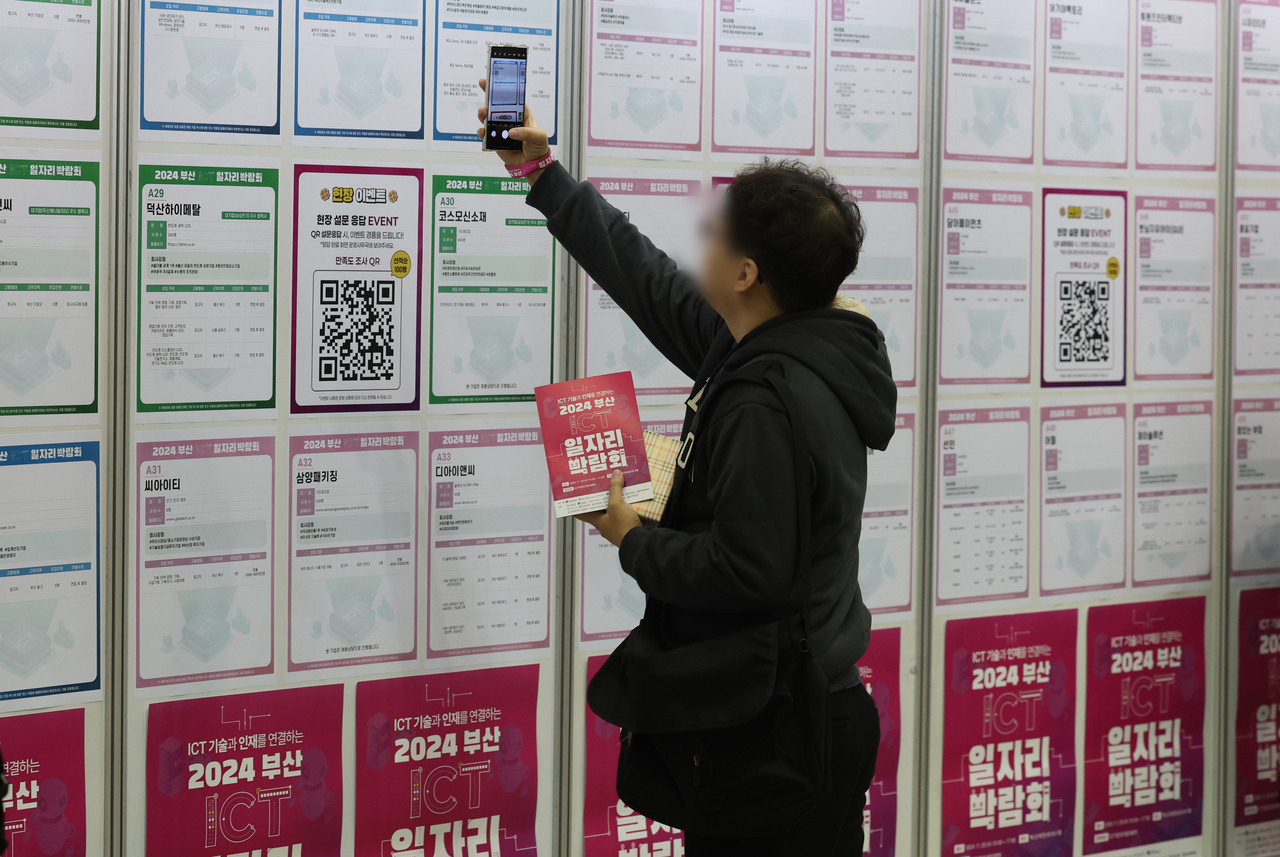 부산 해운대구 벡스코 제2전시장에서 한 구직자가 채용공고 게시판을 살펴보고 있다.  [연합]