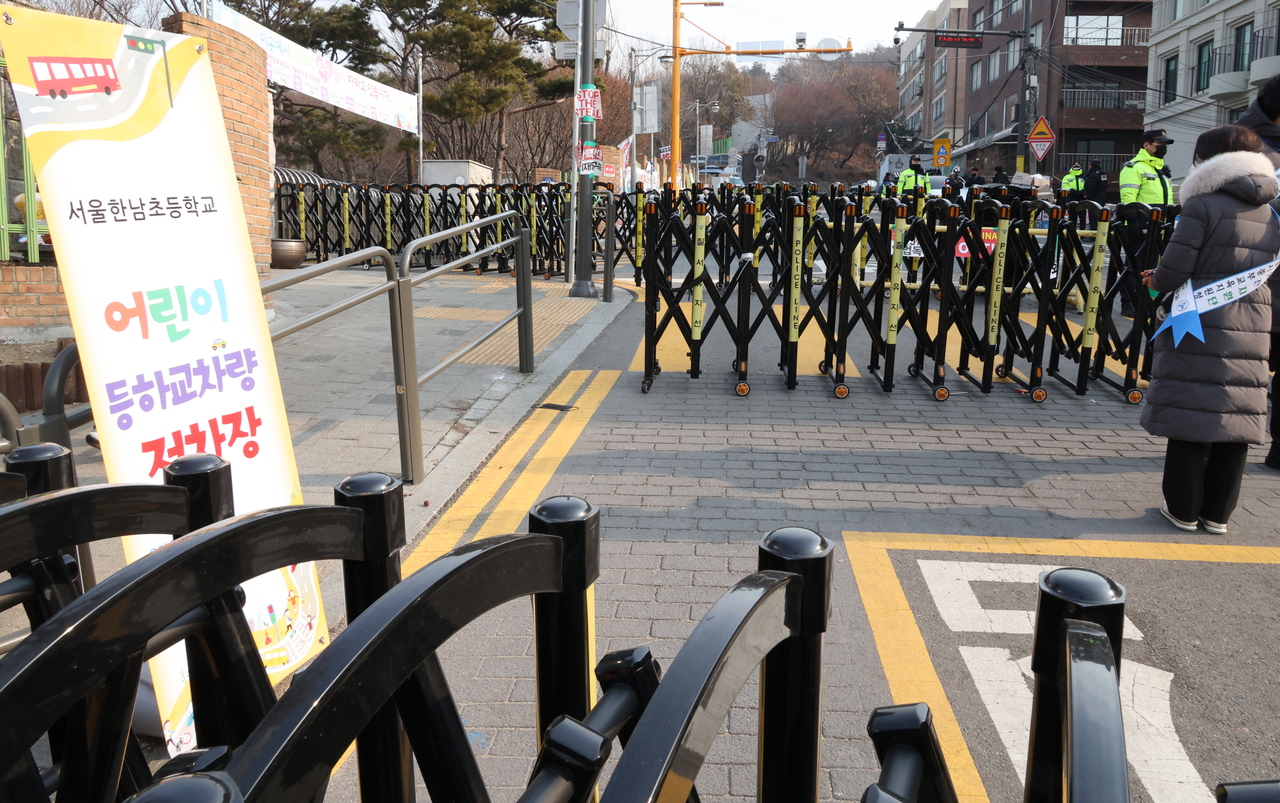 윤석열 대통령 탄핵을 둘러싼 찬반 집회가 연일 이어진 1월 13일 오전 서울 용산구 한남동 한남초등학교 앞에서 통학안전지원단 관계자가 돌봄교실 학생 승하차를 위해 대기해 있다. [연합]