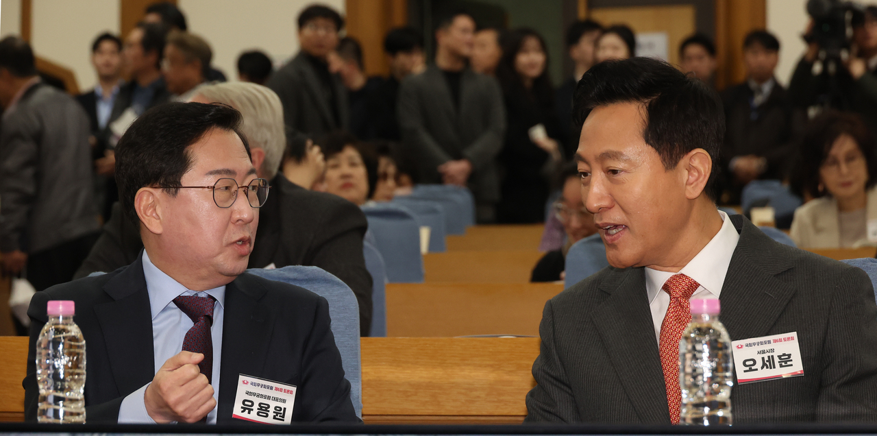 People Power Party Rep. Yu Yong-weon speaks with Seoul Mayor Oh Se-hoon at the forum discussing South Korea acquiring nuclear latency on Tuesday. Yonhap