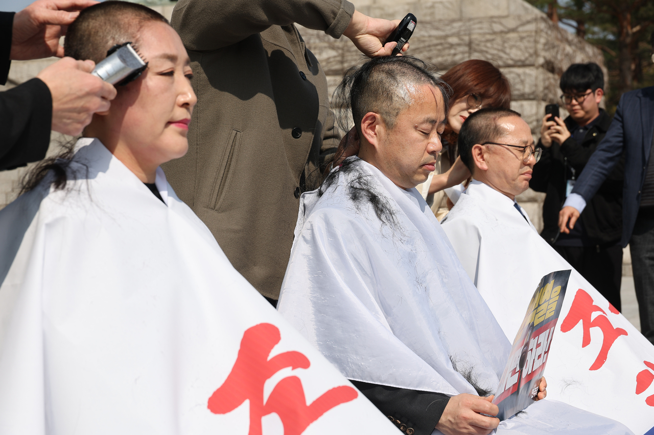 From left: Democratic Party of Korea Reps. Jeon Jin-sook, Park Hong-bae and Kim Moon-soo shave their hands calling for a swift impeachment of the suspended President Yoon Suk Yeol on Tuesday. Yonhap